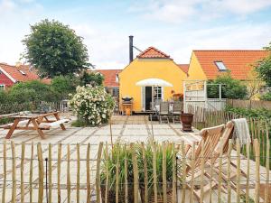 podwórko z żółtym domem i stołem piknikowym w obiekcie 4 person holiday home in S by w mieście Sæby