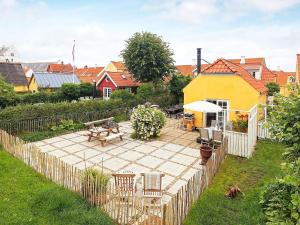 une arrière-cour avec une table de pique-nique et une clôture dans l'établissement 4 person holiday home in S by, à Sæby