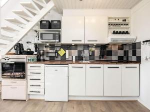 una cocina blanca con armarios y electrodomésticos blancos en Apartment Vestervig III, en Vestervig