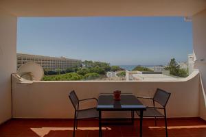 d'une table et de chaises sur un balcon avec vue. dans l'établissement Apartamento Olhos D'Água VistaBella, à Olhos de Água