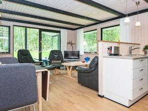 een keuken en een woonkamer met stoelen en een tafel bij Holiday home Skanderborg V in Skanderborg