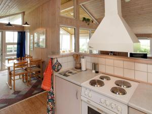 a kitchen with a stove and a dining room at Holiday home Vinderup in Vinderup