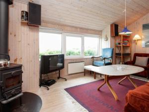 ein Wohnzimmer mit einem Tisch und einem TV in der Unterkunft Holiday home Vinderup in Vinderup