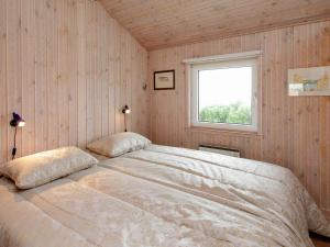 a bedroom with a large bed with a window at Holiday home Vinderup in Vinderup