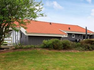 ein Haus mit einem orangenen Dach und einem Hof in der Unterkunft Holiday home Vinderup in Vinderup