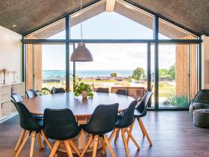 una sala da pranzo con tavolo e sedie e una grande finestra di Panoramic Retreat with Pool - By Traum Ferienwohnungen a Sjølund
