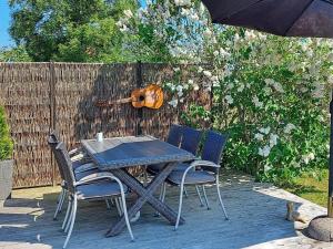 een tafel en stoelen op een terras met een viool bij 6 person holiday home in Frederikshavn in Frederikshavn