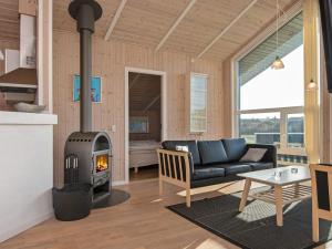 a living room with a black couch and a fireplace at 6 person holiday home in Tarm in Tarm