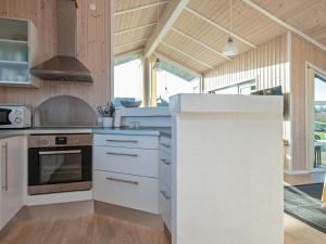a kitchen with white cabinets and a stove at 6 person holiday home in Tarm in Tarm