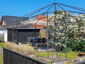 6 person holiday home in Frederikshavn في فريكشهاون: حديقة فيها طاولة وكراسي ومظلة