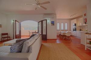 a living room with a couch and a dining room at Apartamento Olhos D'Água VistaBella in Olhos de Água