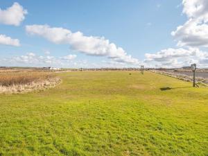 a field with green grass and clouds in the sky at 12 person holiday home in Lemvig in Ferring
