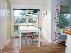 eine Küche mit einem weißen Tisch und Stühlen sowie einem Fenster in der Unterkunft 6 person holiday home in Knebel in Knebel