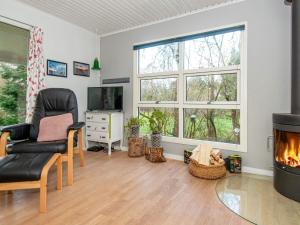ein Wohnzimmer mit einem Kamin und einem Stuhl in der Unterkunft 6 person holiday home in Knebel in Knebel