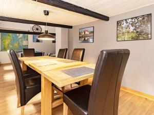 une salle à manger avec une table en bois et des chaises noires dans l'établissement Holiday home Søby Ærø II, à Leby