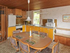 Helberskovにある6 person holiday home in Hadsundのキッチン(テーブル、椅子付)