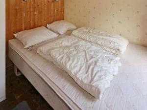 Helberskovにある6 person holiday home in Hadsundの白いシーツと枕が備わるベッド1台