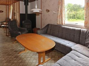 Helberskovにある6 person holiday home in Hadsundのリビングルーム(ソファ、テーブル付)