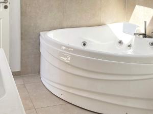 a white bath tub sitting in a bathroom at 6 person holiday home in Bjert in Sønder Bjert