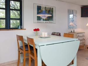 una cocina con una isla blanca con sillas y mesa en 5 person holiday home in Bog By en Bogø By