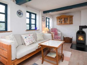 uma sala de estar com um sofá e um fogão a lenha em 5 person holiday home in Bog By em Bogø By
