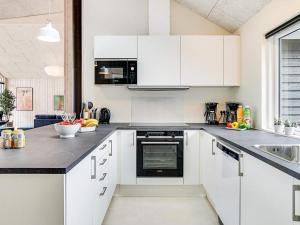 eine weiße Küche mit weißen Schränken und einem Waschbecken in der Unterkunft 14 person holiday home in Vejby in Vejby