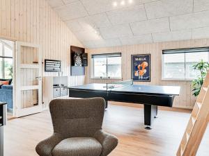 ein Wohnzimmer mit einem Billardtisch und einem Stuhl in der Unterkunft 14 person holiday home in Vejby in Vejby