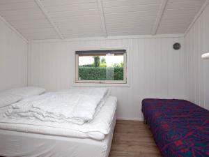 Habitación blanca con cama y ventana en 6 person holiday home in Str by, en Strøby