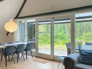 Spidsegårdにある5 person holiday home in Nexのダイニングルーム(テーブル、椅子、ガラスのスライドドア付)