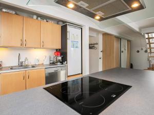 a kitchen with a black counter top and wooden cabinets at Holiday home Otterup XXII in Otterup