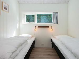 two beds in a small room with a window at Holiday home Ansager XXXVII in Ansager