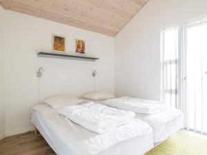 - une chambre blanche avec 2 lits et une fenêtre dans l'établissement Holiday home Fanø CLXXIII, à Fanø