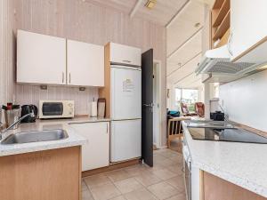 a kitchen with white cabinets and a refrigerator at 6 person holiday home in Rudk bing in Spodsbjerg