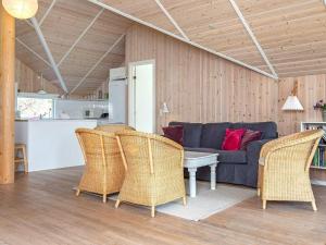 10 person holiday home in Stege في شتايغ: غرفة معيشة مع أريكة زرقاء وكراسي الخوص