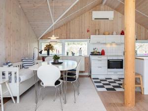 a kitchen and dining room with a table and chairs at 10 person holiday home in Stege in Stege
