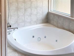 a white bath tub in a bathroom with a window at 6 person holiday home in Jerup in Jerup