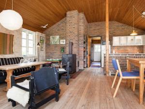 a living room with a brick wall and a table and chairs at Holiday Home Elvervej in Ågerup