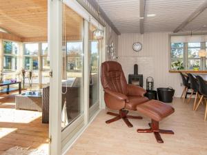 ein Wohnzimmer mit einem Ledersessel und einem Tisch in der Unterkunft 6 person holiday home in Ulfborg in Ulfborg