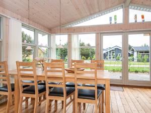 ein Esszimmer mit einem Holztisch und Stühlen in der Unterkunft 6 person holiday home in Ulfborg in Ulfborg