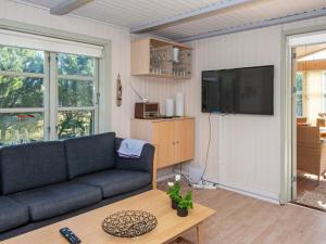 ein Wohnzimmer mit einem Sofa und einem Flachbild-TV in der Unterkunft 6 person holiday home in Ulfborg in Ulfborg