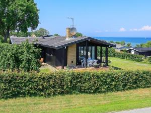 una pequeña casa con un porche cubierto en 6 person holiday home in Hesselager, en Hesselager