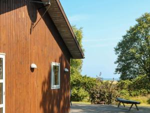 Oddeにある8 person holiday home in Hadsundの納屋の横にベンチがある