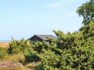 Oddeにある8 person holiday home in Hadsundの田畑の木に覆われた家