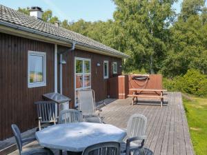 Oddeにある8 person holiday home in Hadsundのパティオ(テーブル、椅子、ベンチ付)