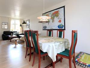 a dining room with a table and chairs with a map on the wall at 6 person holiday home in R dby in Rødby