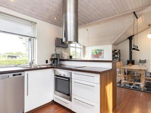 una cocina con armarios blancos y fregadero en 8 person holiday home in Skals, en Hjarbæk