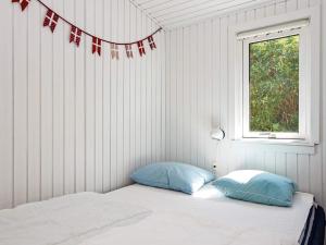 a bedroom with a bed with two pillows and a window at Holiday home Hejls LVI in Hejls
