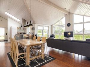a dining room and living room with a table and chairs at 8 person holiday home in Skals in Hjarbæk