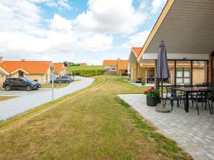 un patio con una mesa y una sombrilla frente a una casa en 8 person holiday home in Egernsund, en Egernsund