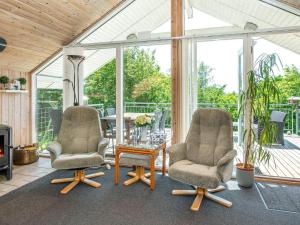 レムにある10 person holiday home in Skjernのコンサバトリー内の椅子2脚とコーヒーテーブル